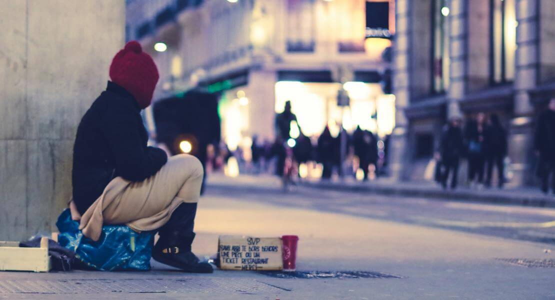 Jeune sans abri assis sur le coin de la rue