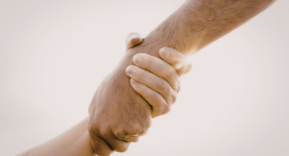 Main tendue vers une autre qui la tient fermement