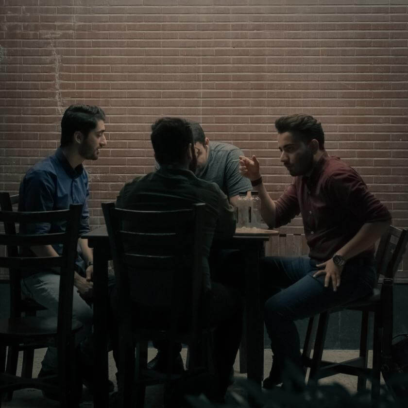 Quatre hommes assis à une table