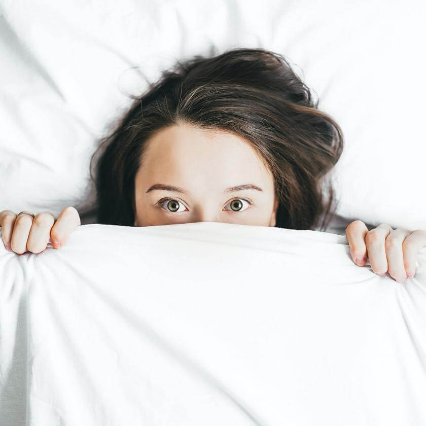 person in a bed with white sheets