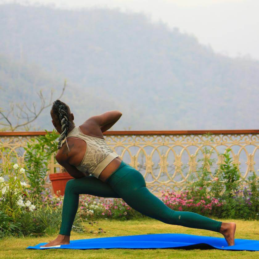 Black person with a feminine appearance in a garden practicing yoga