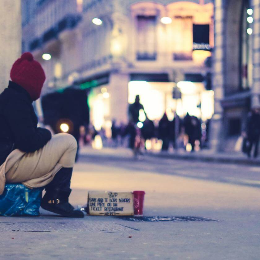 Jeune sans abri assis sur le coin de la rue