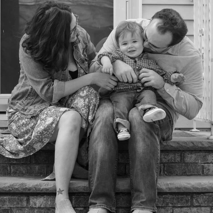 Une femme et un homme assis tenant un petit enfant