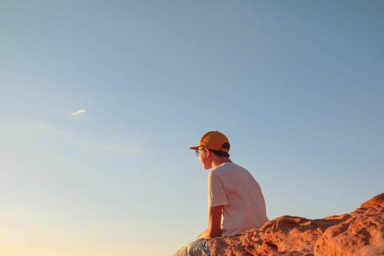 Jeune sur le bord d'une montagne -Joshua Sukoff